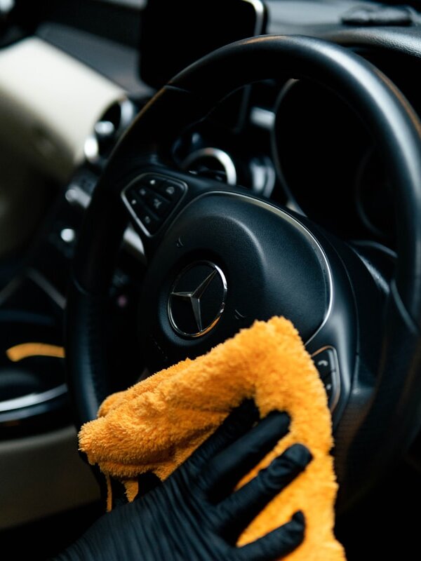 Steering wheel and interior trim being cleaned with a microfibre cloth